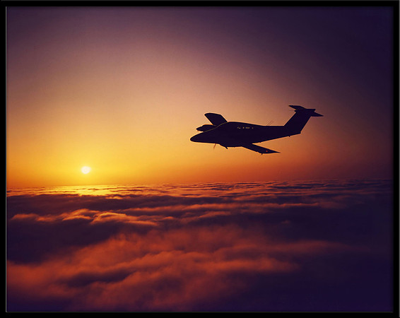 Air-to-air photo at sunset of a Beechcraft Duchess over Santa Cruz, CA